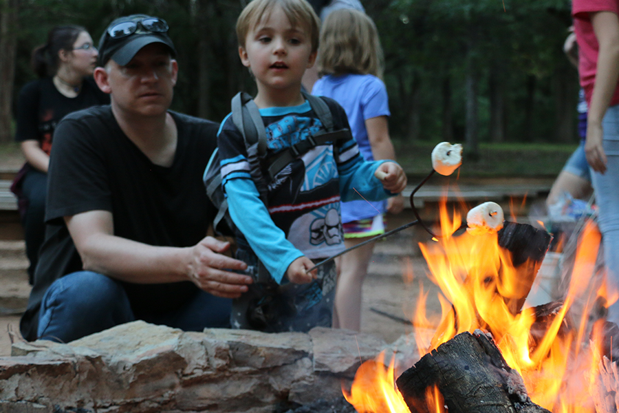 father and son roasting marshmallows over campfire
